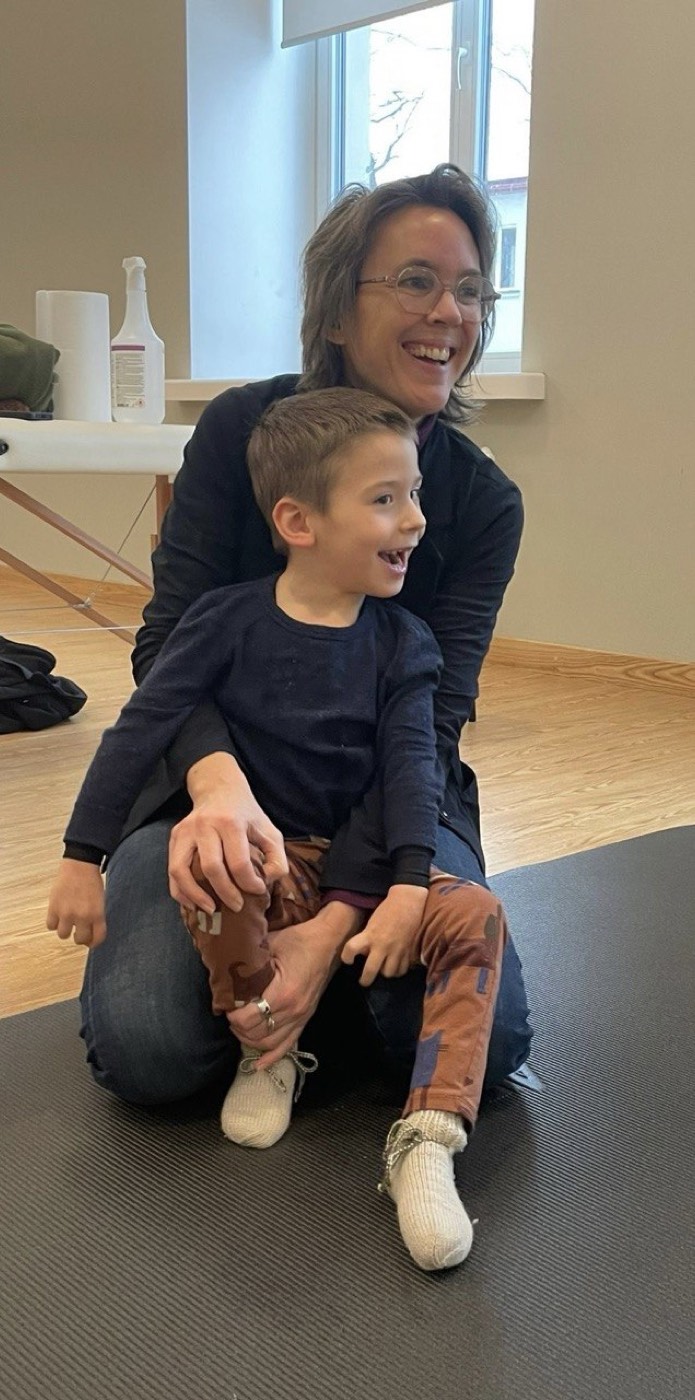 A boy sitting on the floor, laughing, after a lesson