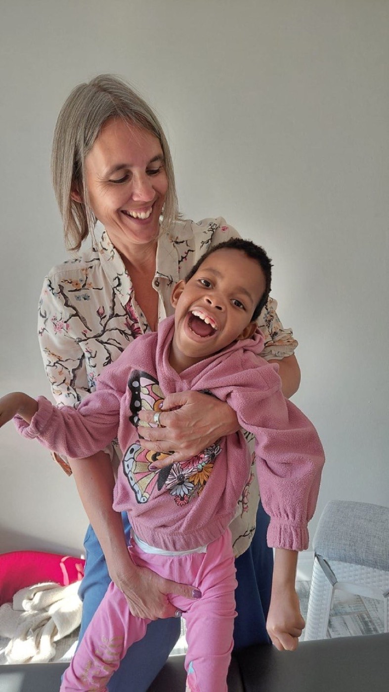 Judith lacht samen met een jong kind tijdens een les